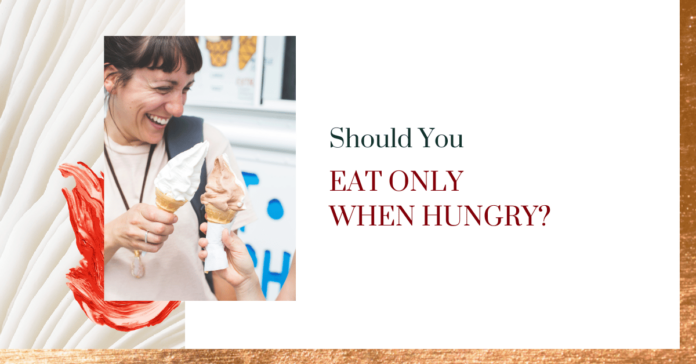 A women with a wide smile is having an ice cream cone with a friend. The image is next to text that reads "Should you eat only when hungry?"